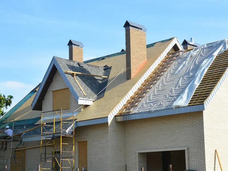 House roof mid-replacement with new underlayment going down over the decking